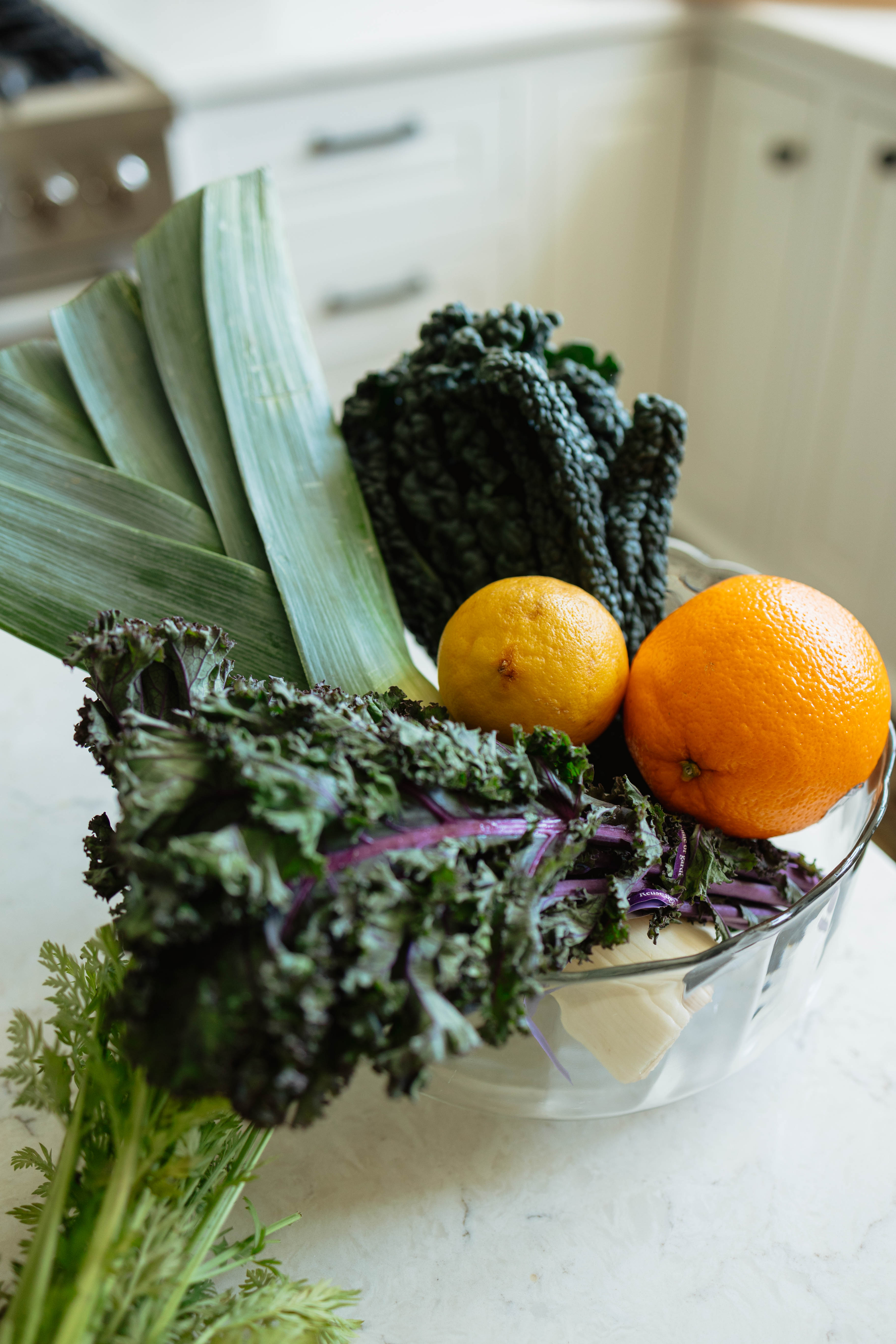Leafy greens and citrus in a glass bowl